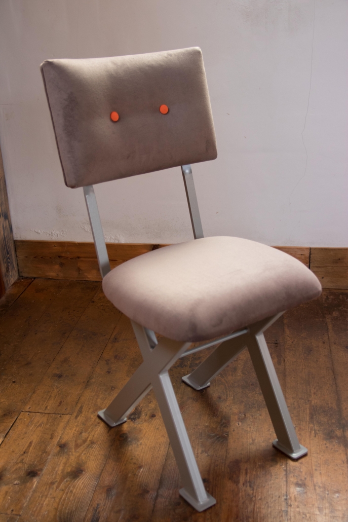 industrial chair with steel legs and contrast button
