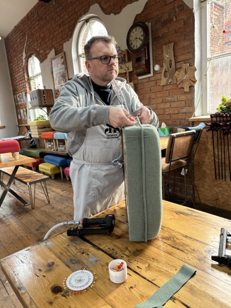 Upholstery workshop making footstool