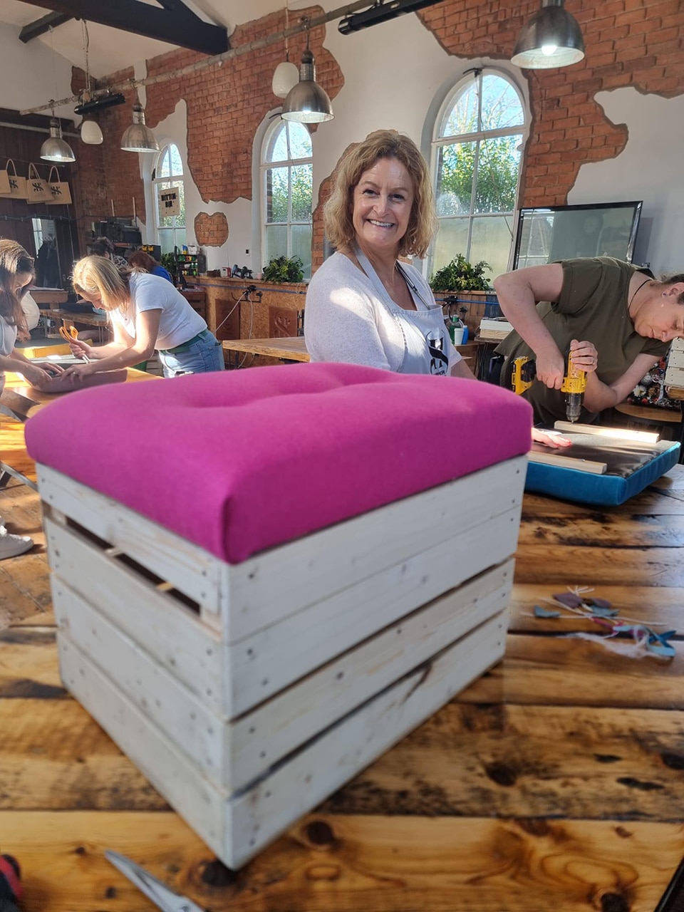 Amanda enjoying a creative team building activity at a storage box upholstery workshop.