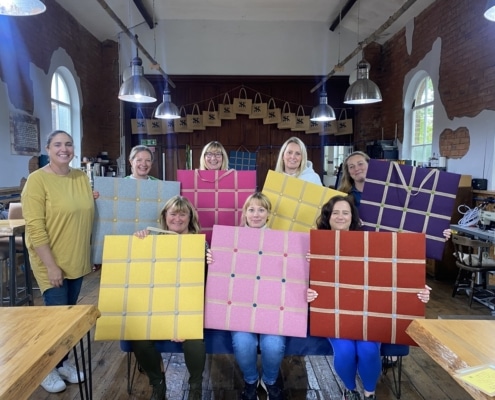 Jenny and group - with finished noticeboards at their upholstery workshop in Cheshire