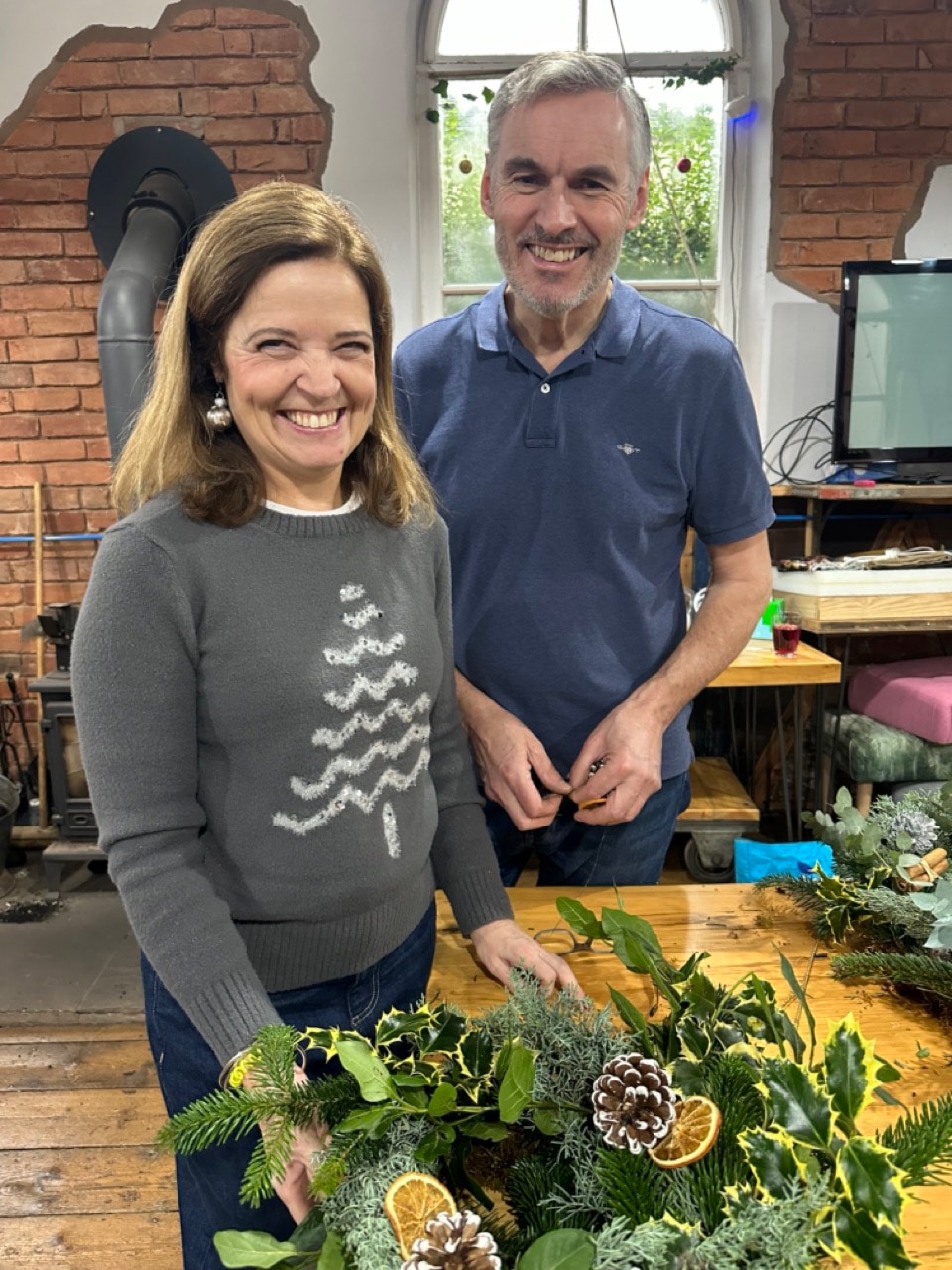 Guests enjoying a Christmas wreath making workshop in a festively decorated chapel in Cheshire
