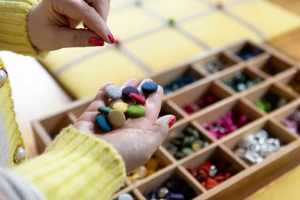 A handful of coloured buttons made using recycled wool fabric