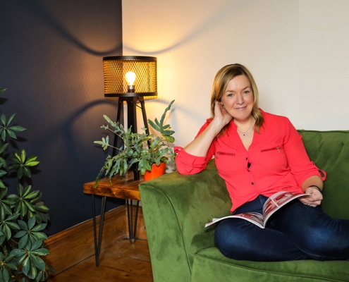 Emma Semper Hopkins sat on a sofa in her home, that she has upholstered.
