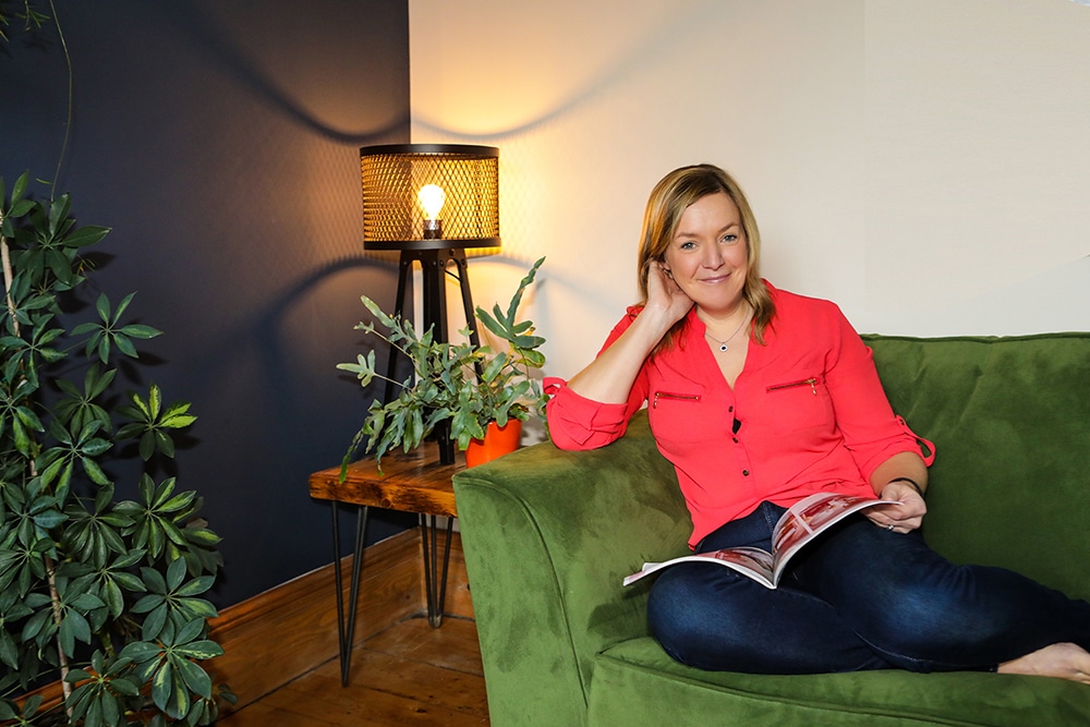 Emma Semper Hopkins sat on a sofa in her home, that she has upholstered.