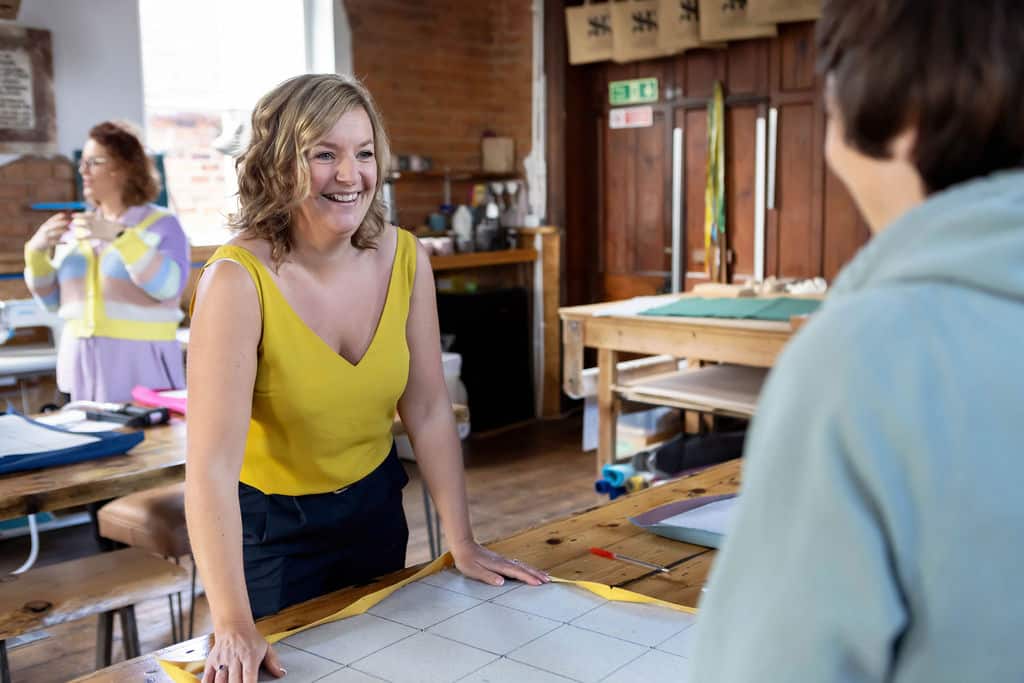 Emma Semper Hopkins teaching during a team building workshop, sharing her perspective on upholstery and leathercraft as creative, sustainable skills.