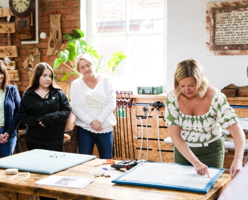 Team members working together on an upholstery project during a team building workshop in Cheshire.