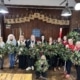 A festive Christmas wreath-making workshop in Cheshire with a group of colleagues creating handmade wreaths, enjoying afternoon tea, and celebrating together.
