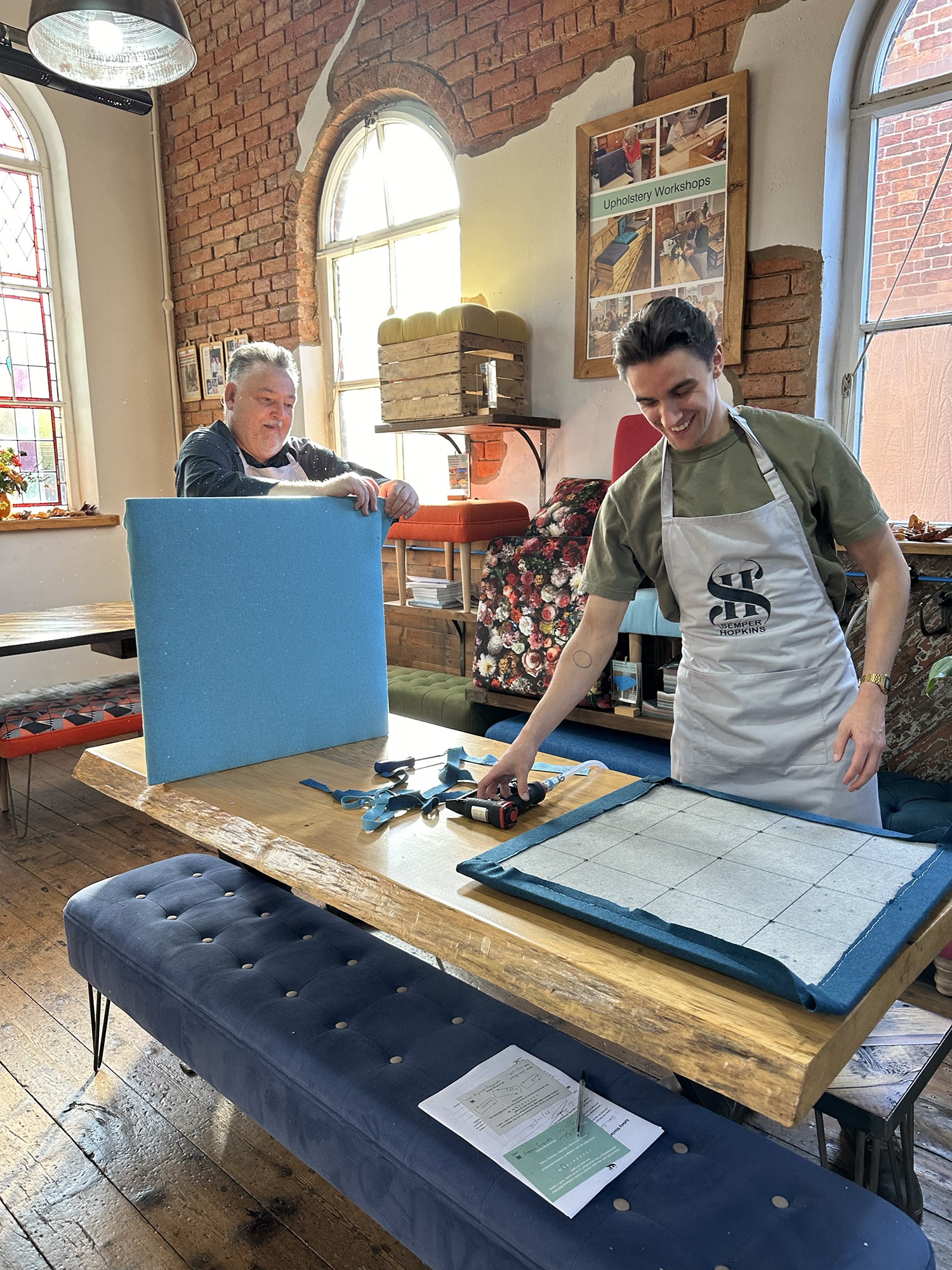 Members of the Apollo Care team working side by side during a creative upholstery team-building workshop at the SHUI chapel in Cheshire