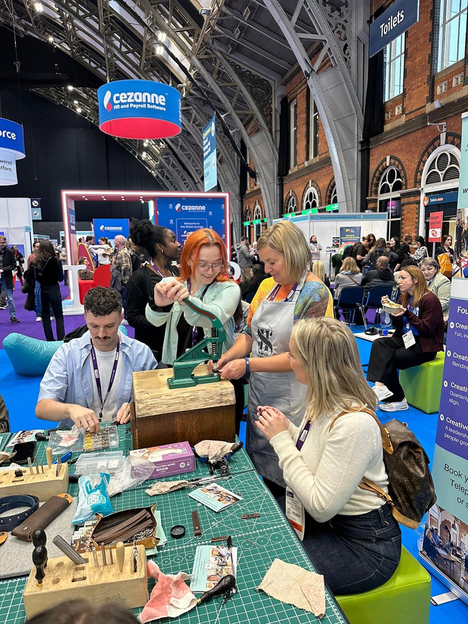 Participants making leather keyrings during Creative Pause workshop.