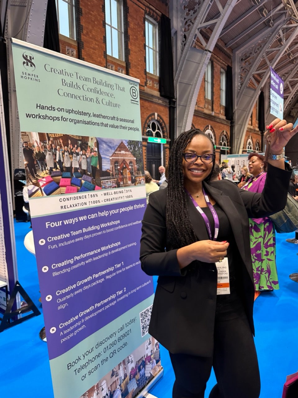 Participants proudly holding leather keyrings made during Creative Pause workshop.