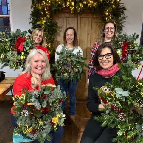 Charlotte Dean enjoying a festive Christmas Wreath Workshop with her team, describing how her expectations were exceeded by the venue, food, training, and fun.