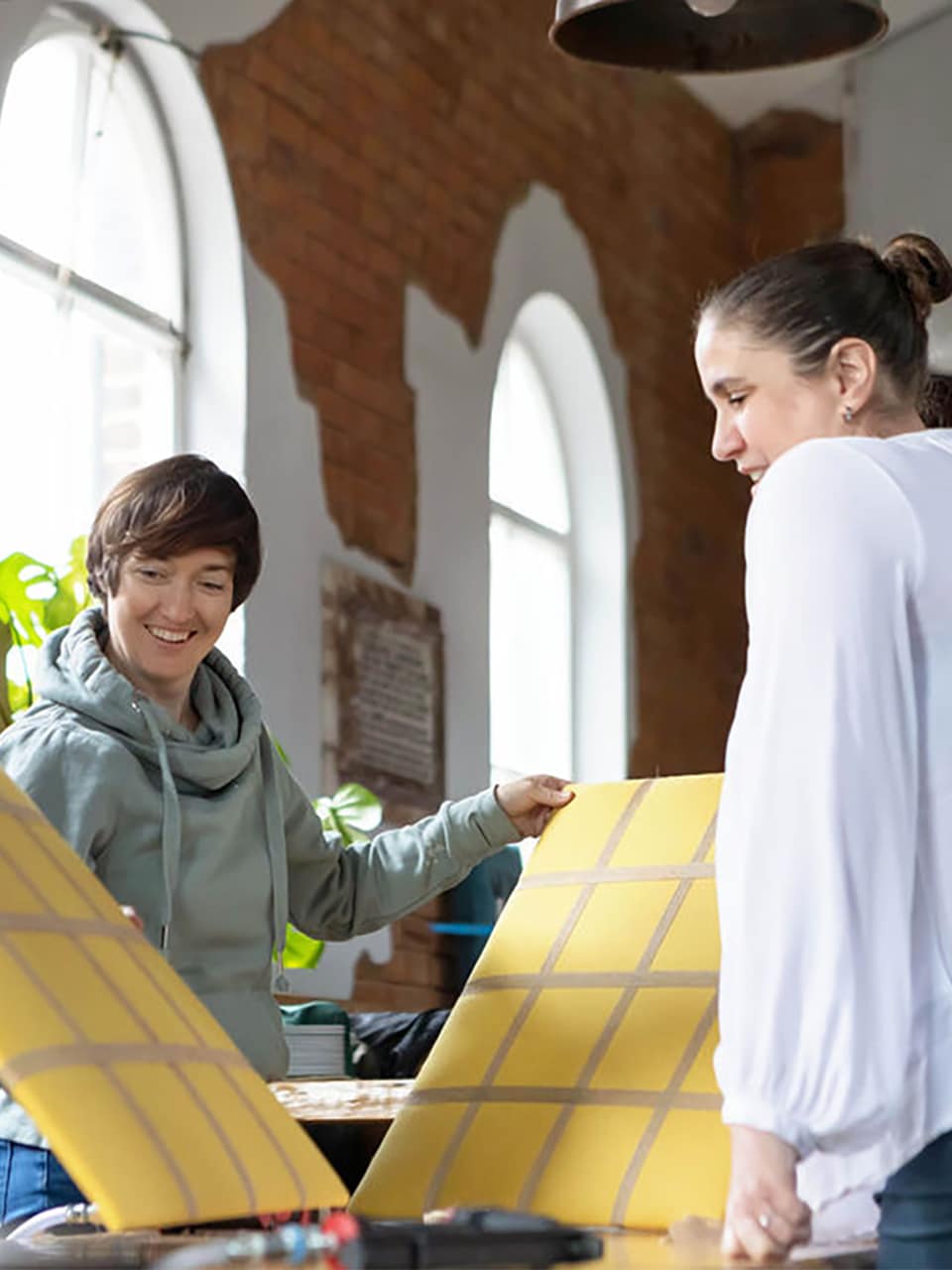 ros-supporting-upholstery-workshop Ros supporting two workshop guests while they compare upholstered panels during a session at the chapel.
